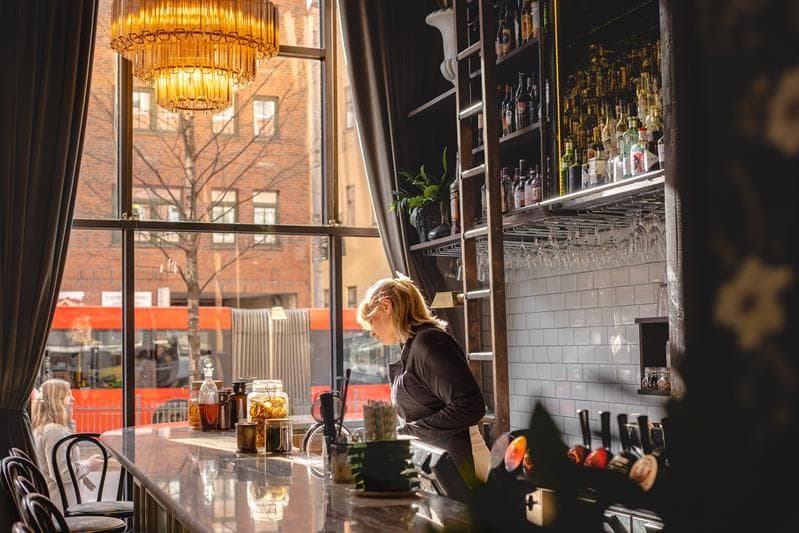 Waitress behind the bar.