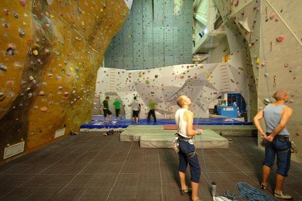 climbing centre with climbing walls and people in climbing clothes